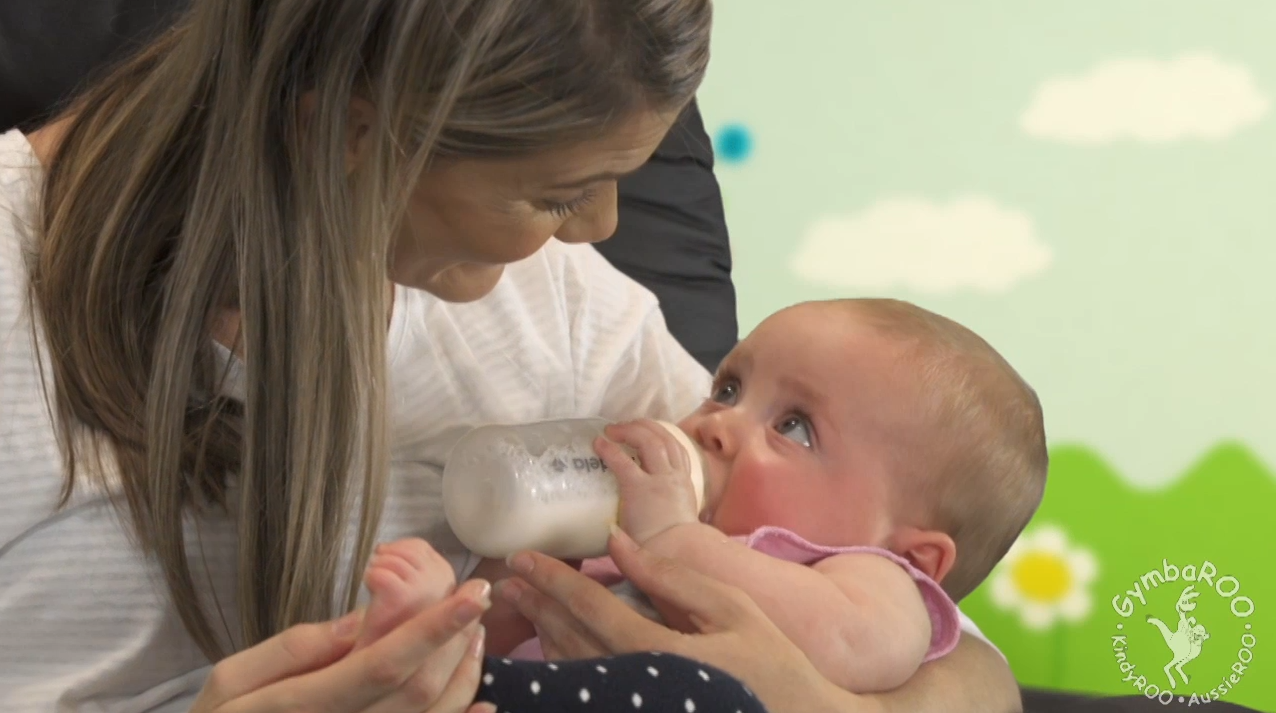 Mum bottle feeding baby. Gymbaroo Babyroo Positioning Baby to Prevent a Flattened Head Shape – Plagiocephaly