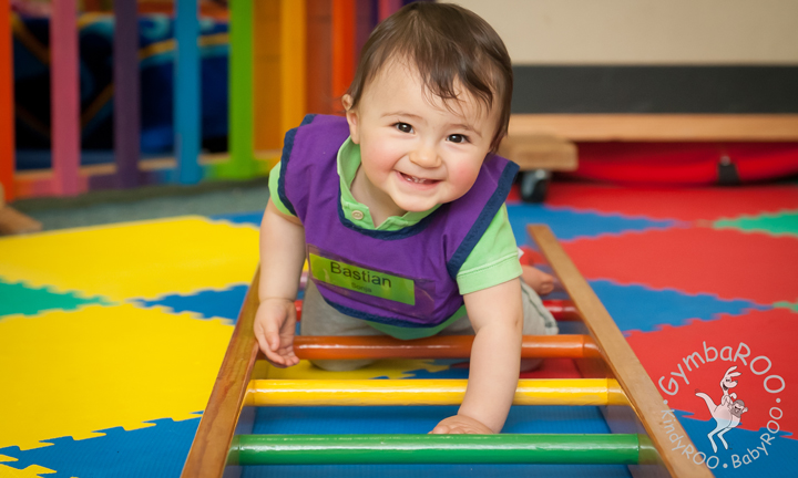 A happy baby crawling on the Gymbaroo equipment and developing strength at Gymbaroo Babyroo