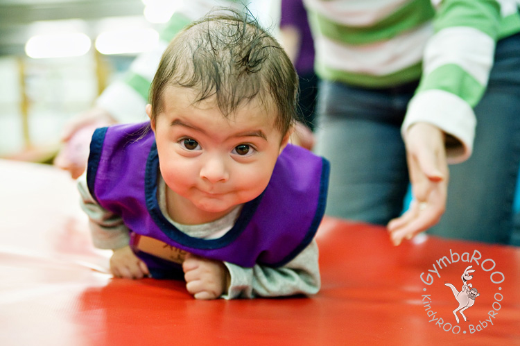 A happy baby crawling on the Gymbaroo equipment and developing strength at Gymbaroo Babyroo